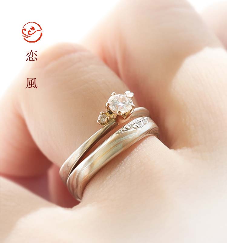 緩やかな風のように流れるカーブが指にしっくりなじむセットリング。婚約指輪（エンゲージリング）と結婚指輪（マリッジリング）がぴったりと重ねづけができるので、一層華やかに。